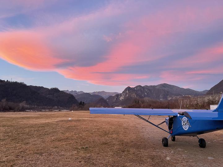 Nubi lenticolari rosa al tramonto sopra le montagne al campo di volo