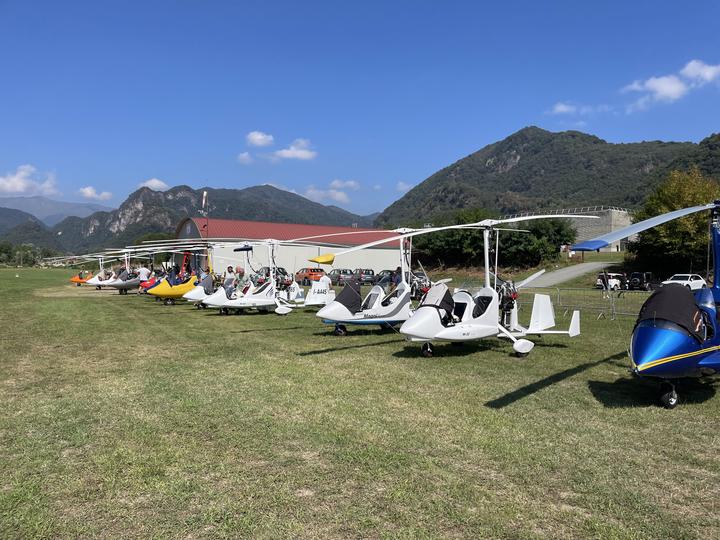 Autogiri e ultraleggeri allineati a un raduno di ala rotante con le colline sullo sfondo