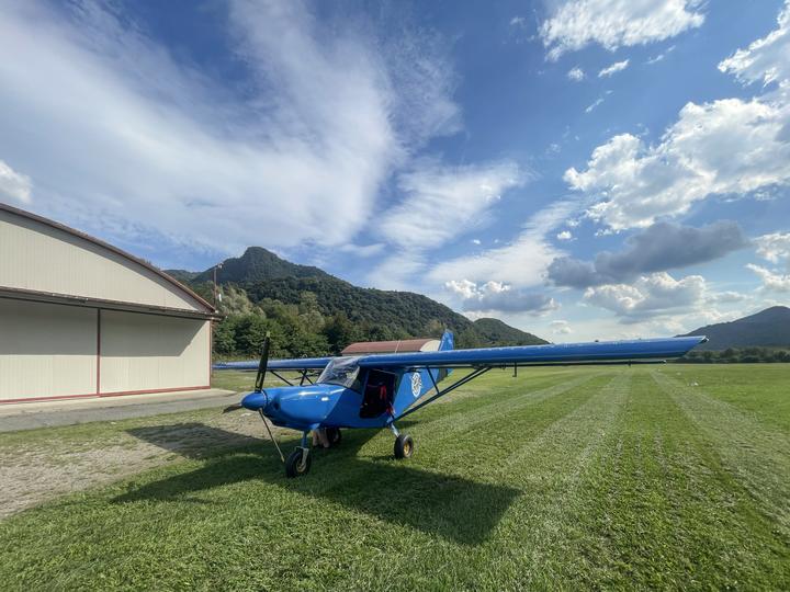 Il Savannah parcheggiato sull'erba davanti all'hangar sotto un cielo di nuvole
